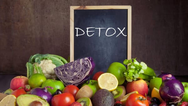 Healthy foods arranged around a chalkboard sign that says detox